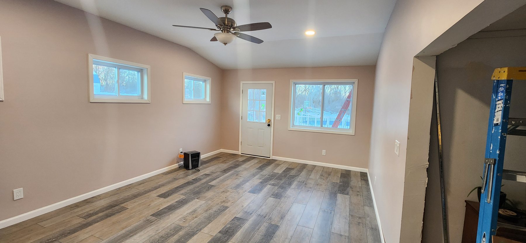 Finished New Beginnings home addition with vaulted ceiling, recessed lighting and new flooring